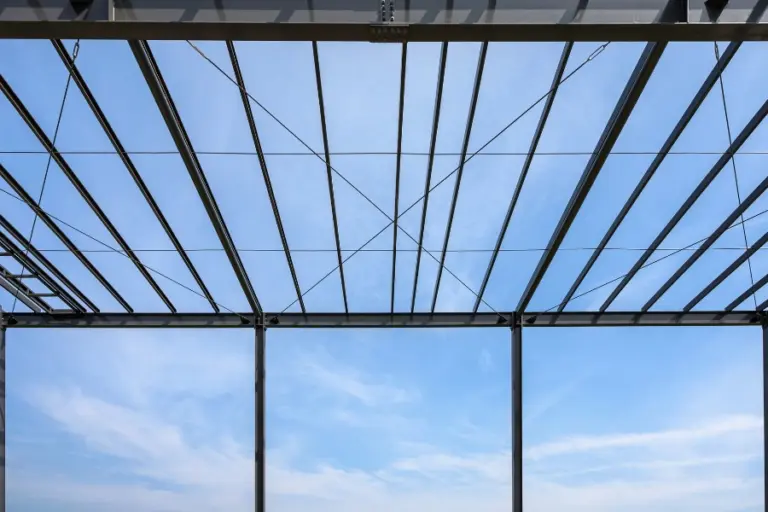 Innenansicht eines Gebäudes mit Aluminiumkonstruktion, das den Himmel zeigt.