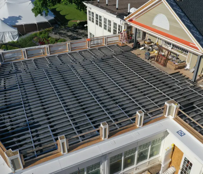 Ein Haus mit einem im Bau befindlichen Dach, umgeben von Aluminium-Balkonsystemen.
