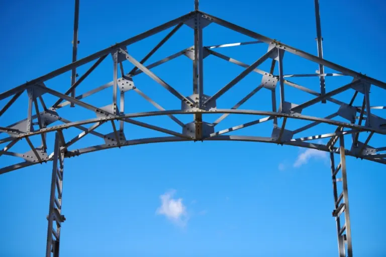 Robuste Metallkonstruktion unter klarem blauen Himmel, repräsentiert die Fertigungstechnik und Schlosserarbeiten.